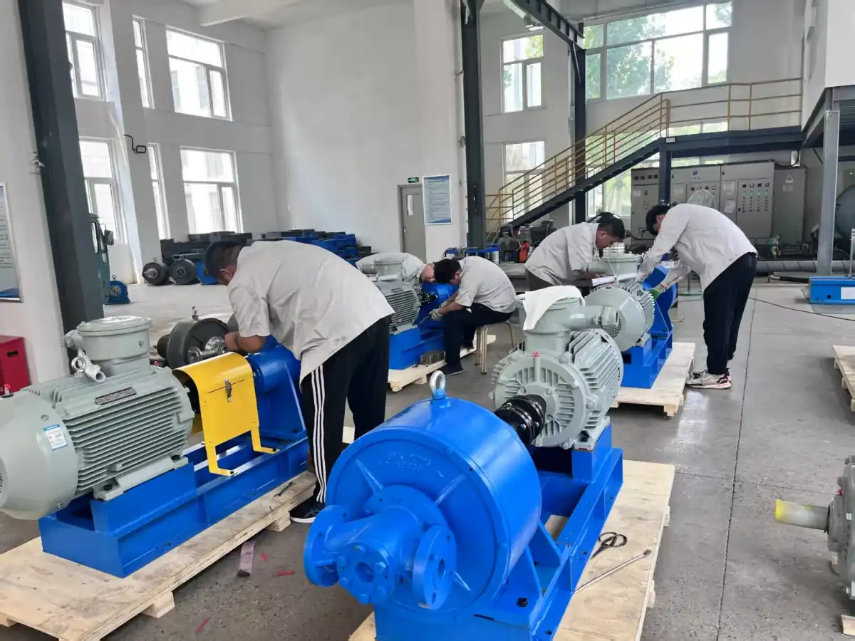 EHIK workshop team assembling pump sets with tools and multiple units